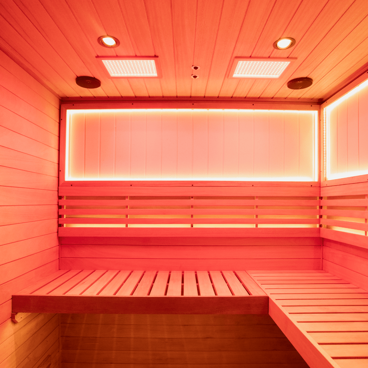 Interior shot of mahogany 4‑person steam sauna with wooden benches and steam heater